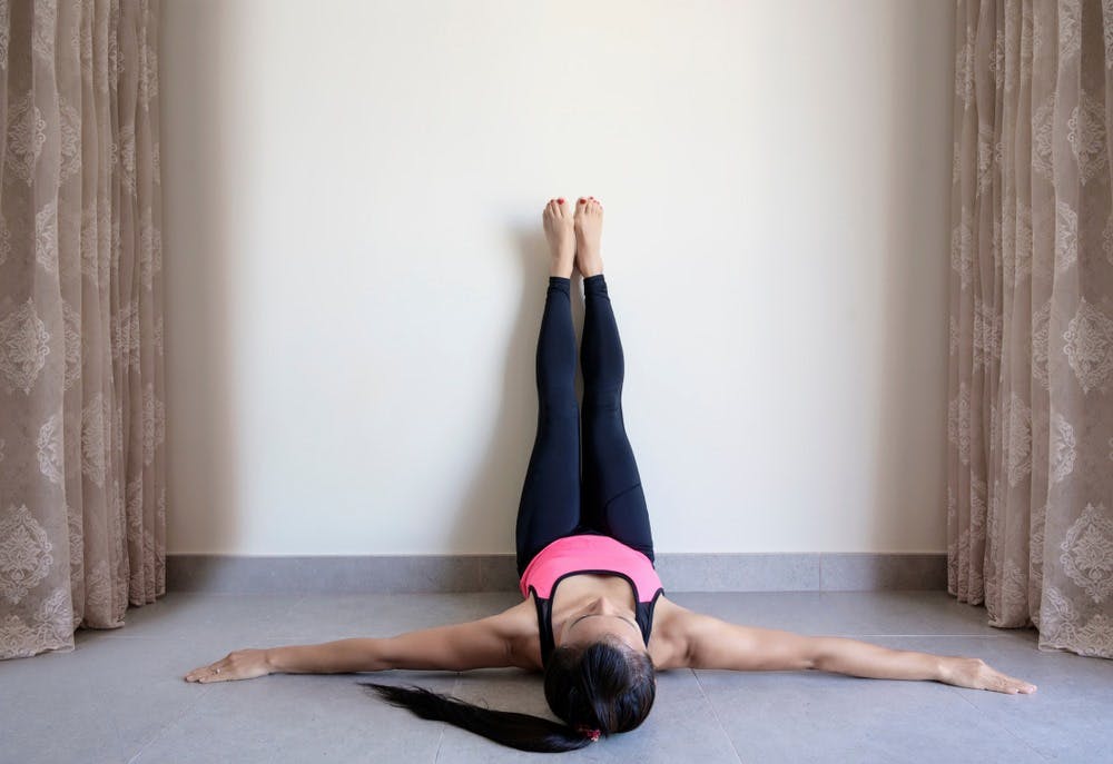 Placing your feet on the wall is one of the yoga poses for cramps